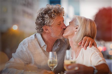 simsearch:6113-07543617,k - Affectionate senior couple kissing drinking white wine at sidewalk cafe Stock Photo - Premium Royalty-Free, Code: 6124-08743228