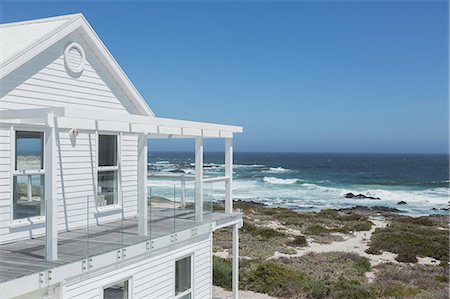 simsearch:6124-08703974,k - White beach house with ocean view under sunny blue sky Stock Photo - Premium Royalty-Free, Code: 6124-08703842