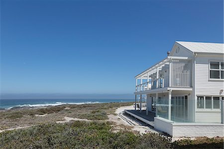 simsearch:6124-08703974,k - White beach house with ocean view under sunny blue sky Stock Photo - Premium Royalty-Free, Code: 6124-08703844