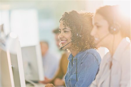 simsearch:6113-07243082,k - Businesswomen with headsets working at computers in office Stock Photo - Premium Royalty-Free, Code: 6124-08703894