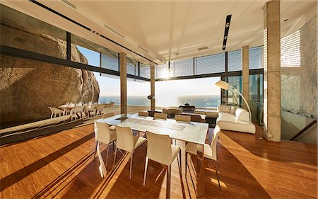 simsearch:6124-08703974,k - Sun shining in modern luxury home showcase dining room with ocean view Stock Photo - Premium Royalty-Free, Code: 6124-08704009