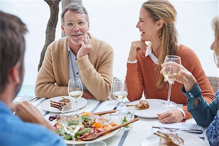 simsearch:6113-08659553,k - Couples drinking white wine and eating lunch at patio table Stock Photo - Premium Royalty-Free, Code: 6124-08805275