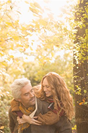 Affectionate couple piggybacking in autumn woods Photographie de stock - Premium Libres de Droits, Code: 6124-08820762