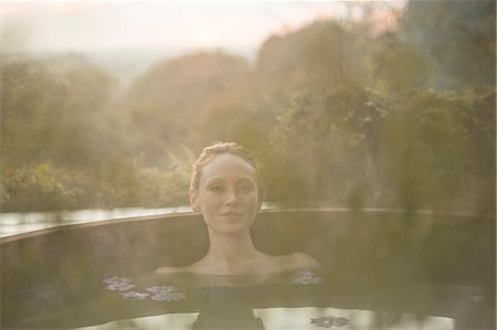 simsearch:6113-07790529,k - Portrait serene woman soaking in hot tub on autumn patio Stock Photo - Premium Royalty-Free, Code: 6124-08820703