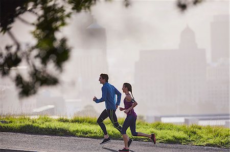 Runner couple running on sunny urban city street Stock Photo - Premium Royalty-Free, Code: 6124-08820852