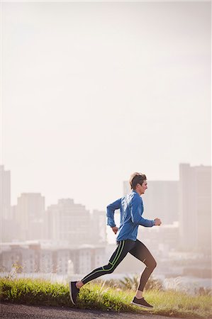 perfil - Male runner running on sunny urban city street Foto de stock - Royalty Free Premium, Número: 6124-08820818