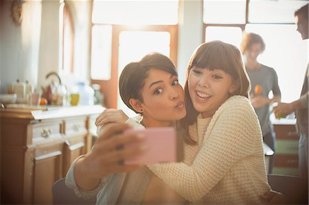 simsearch:6113-06908601,k - Playful young friends taking selfie with camera phone making a face Stock Photo - Premium Royalty-Free, Code: 6124-08821058