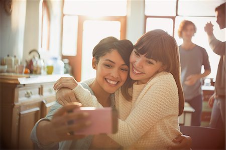 simsearch:6113-06908601,k - Young women friends taking selfie with camera phone in apartment Stock Photo - Premium Royalty-Free, Code: 6124-08821032