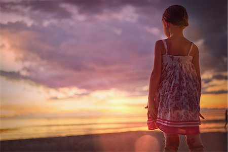 simsearch:649-09078617,k - Pensive girl watching tranquil sunset in dramatic sky over ocean Stock Photo - Premium Royalty-Free, Code: 6124-08945971