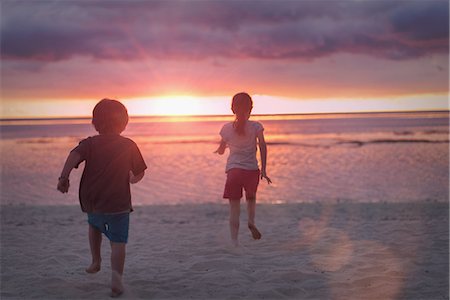 simsearch:649-06352471,k - Boy and girl brother and sister on tranquil sunset beach with dramatic sky Stock Photo - Premium Royalty-Free, Code: 6124-08945991
