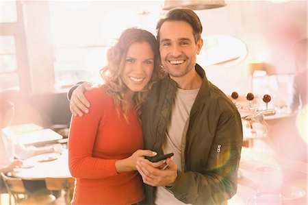 simsearch:6113-07565751,k - Portrait affectionate smiling couple using cell phone in bar Stock Photo - Premium Royalty-Free, Code: 6124-08946088