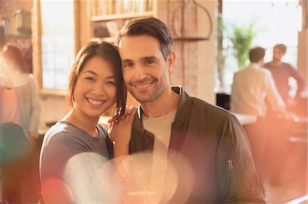 simsearch:6113-07565751,k - Portrait smiling affectionate couple hugging in cafe Stock Photo - Premium Royalty-Free, Code: 6124-08946039