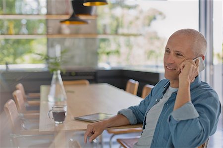 simsearch:649-07520071,k - Smiling mature man talking on cell phone at dining table Stock Photo - Premium Royalty-Free, Code: 6124-08908114