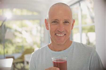 Portrait smiling, confident mature man drinking healthy fruit smoothie Stock Photo - Premium Royalty-Free, Code: 6124-08908133