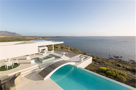 simsearch:6113-07147822,k - Sunny, tranquil modern luxury home showcase exterior with infinity pool and ocean view Photographie de stock - Premium Libres de Droits, Code: 6124-08908240