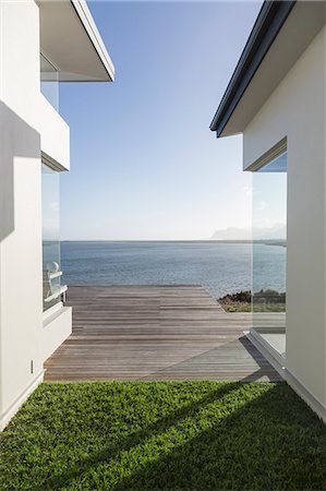 simsearch:6124-08703974,k - Modern home showcase exterior courtyard with sunny, tranquil ocean view Stock Photo - Premium Royalty-Free, Code: 6124-08908207