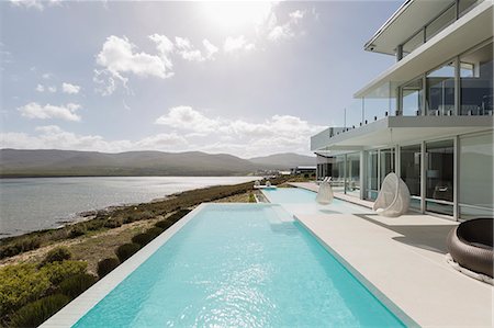 simsearch:6113-07147822,k - Sunny, tranquil modern luxury home showcase exterior with infinity pool and ocean view Photographie de stock - Premium Libres de Droits, Code: 6124-08908205