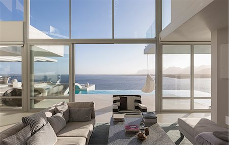 simsearch:6113-07542742,k - Sunny, tranquil modern luxury home showcase interior living room with patio and ocean view Stock Photo - Premium Royalty-Free, Code: 6124-08908221