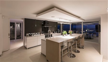 Illuminated modern luxury home showcase interior kitchen at night Stock Photo - Premium Royalty-Free, Code: 6124-08908233