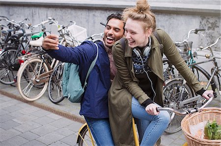female biking - Playful, laughing young couple taking selfie with camera phone on bicycle Stock Photo - Premium Royalty-Free, Code: 6124-08926826