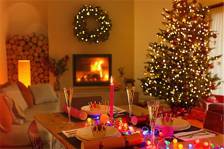 Ambient Christmas dinner table in living room with fireplace and Christmas tree Stock Photo - Premium Royalty-Free, Code: 6124-08926940