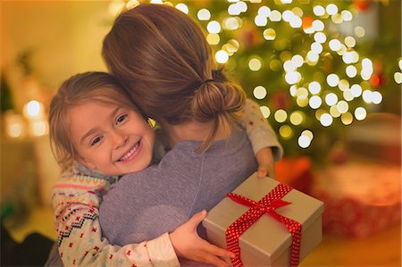 simsearch:6113-07543218,k - Smiling daughter with Christmas gift hugging mother Stock Photo - Premium Royalty-Free, Code: 6124-08926948