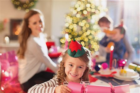 simsearch:6113-07543218,k - Portrait smiling girl holding Christmas cracker at dinner table Stock Photo - Premium Royalty-Free, Code: 6124-08926951