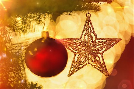 Close up red ornament and gold star hanging from branch of Christmas tree Photographie de stock - Premium Libres de Droits, Code: 6124-08926958