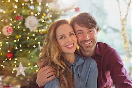 simsearch:649-06716867,k - Portrait smiling couple hugging in front of Christmas tree Stock Photo - Premium Royalty-Free, Code: 6124-08926967