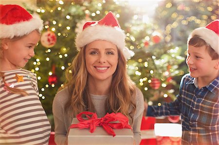 simsearch:640-03260410,k - Portrait smiling mother in Santa hat receiving Christmas gift from daughter and son Stock Photo - Premium Royalty-Free, Code: 6124-08926990