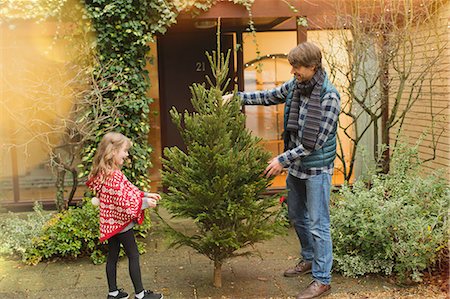 front stoop - Father and daughter with Christmas tree outside house Stock Photo - Premium Royalty-Free, Code: 6124-08926903