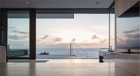 simsearch:6124-08703974,k - Home showcase living room and patio with tranquil sunset ocean view Stock Photo - Premium Royalty-Free, Code: 6124-08927073