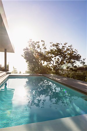 simsearch:6113-07147822,k - Tranquil sunny reflection of tree over lap swimming pool on luxury patio Photographie de stock - Premium Libres de Droits, Code: 6124-08927031