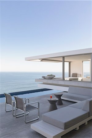 simsearch:6124-08703974,k - Modern, luxury home showcase exterior patio with ocean view Stock Photo - Premium Royalty-Free, Code: 6124-09099895