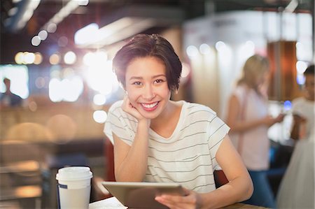 simsearch:614-02985269,k - Portrait smiling young woman using digital tablet and drinking coffee in cafe Stock Photo - Premium Royalty-Free, Code: 6124-09004861