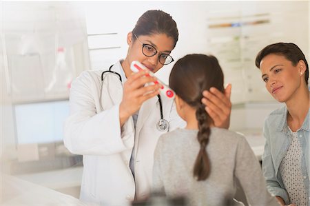 Female doctor using digital thermometer in ear of girl patient in examination room Photographie de stock - Premium Libres de Droits, Code: 6124-09026370