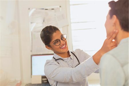 simsearch:6113-06720629,k - Female doctor checking neck lymph node glands of patient in examination room Foto de stock - Sin royalties Premium, Código: 6124-09026394