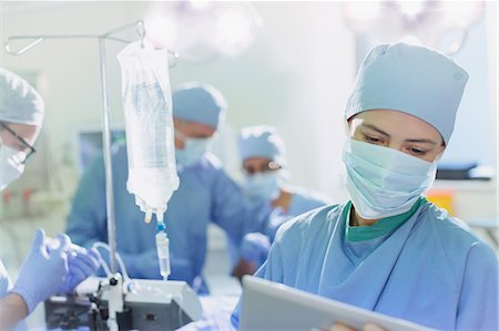 simsearch:649-06000982,k - Female surgeon wearing surgical mask using digital tablet in operating room Stock Photo - Premium Royalty-Free, Code: 6124-09026407