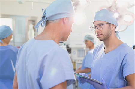 surgical gown - Male surgeons with digital tablet talking in operating room Stock Photo - Premium Royalty-Free, Code: 6124-09026405