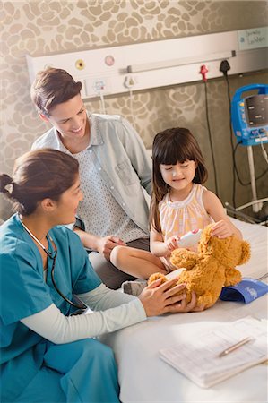 pediatric - Female nurse and girl patient using digital thermometer on teddy bear in hospital room Stock Photo - Premium Royalty-Free, Code: 6124-09026406