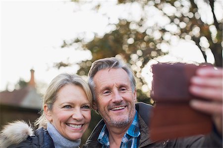simsearch:6113-06498180,k - Smiling, happy mature couple taking selfie with camera phone Stock Photo - Premium Royalty-Free, Code: 6124-09167275