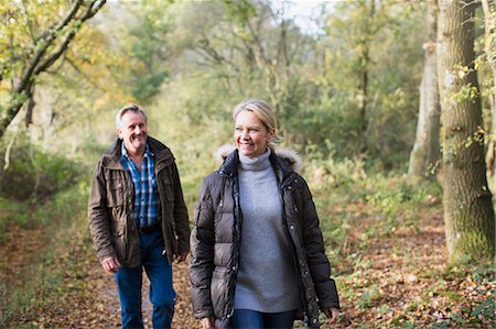 simsearch:400-04035087,k - Smiling mature couple walking in sunny autumn woods Stock Photo - Premium Royalty-Free, Code: 6124-09167282
