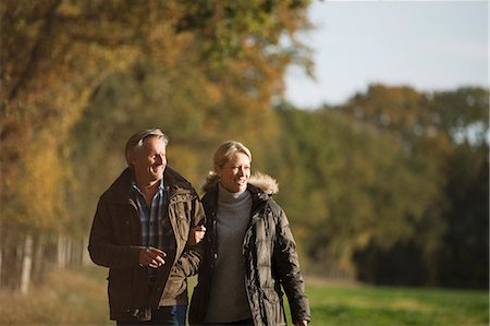 simsearch:6113-07589438,k - Mature couple walking arm in arm in sunny autumn park Stock Photo - Premium Royalty-Free, Code: 6124-09167220