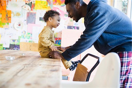 simsearch:6116-07236010,k - Happy father and son at dining table Stock Photo - Premium Royalty-Free, Code: 6124-09167316