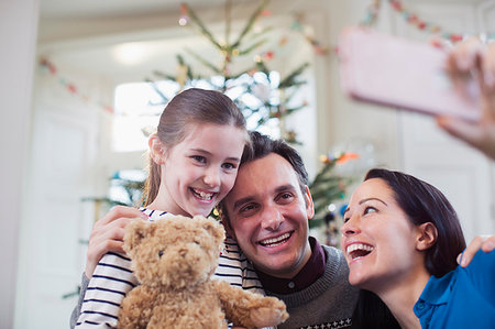 simsearch:6113-06498556,k - Happy parents and daughter taking selfie in front of Christmas tree Stock Photo - Premium Royalty-Free, Code: 6124-09177898