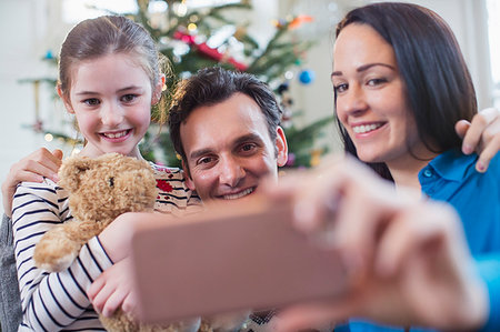 father christmas family portrait - Happy family with smart phone taking selfie in Christmas living room Photographie de stock - Premium Libres de Droits, Code: 6124-09177982