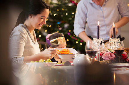 simsearch:6113-07147647,k - Woman serving carrots at candlelight Christmas dinner Stock Photo - Premium Royalty-Free, Code: 6124-09177900