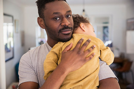 simsearch:6116-07236010,k - Portrait affectionate father holding tired baby son Stock Photo - Premium Royalty-Free, Code: 6124-09178041