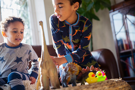 Brothers in pajamas playing with dinosaur toys Stock Photo - Premium Royalty-Free, Code: 6124-09178038