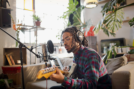 simsearch:614-06719795,k - Young male musician recording music, playing guitar at microphone in apartment Stock Photo - Premium Royalty-Free, Code: 6124-09188496